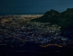 Nighttime aerial view of Cape Town with a digital grid overlay.